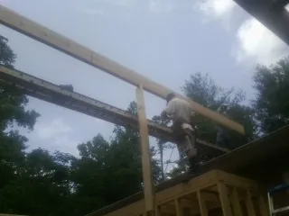Carpenter setting a ridge beam over a new addition frame — Ice Dam Removal by Roofing Brothers in Silver Springs